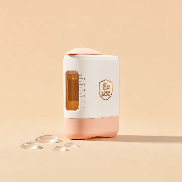 Refillable manual scalp applicator with an amber 6 mL window and a gold YOUR BRAND shield, beads of clear serum beside it on peach